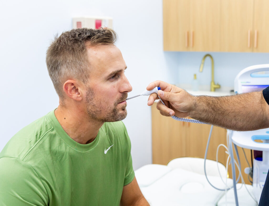 “Doctor using a digital thermometer to check a patient’s temperature during a routine medical examination in a well-lit clinic.”