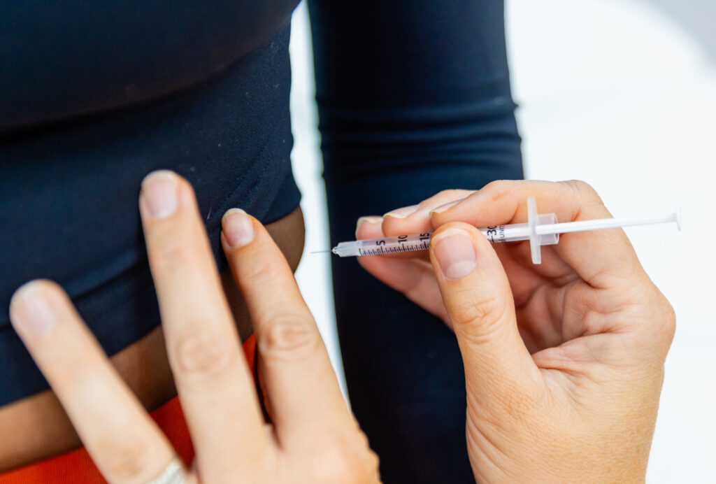 “Doctor administering a medication injection to a patient, ensuring proper technique in a safe and professional clinical environment.”